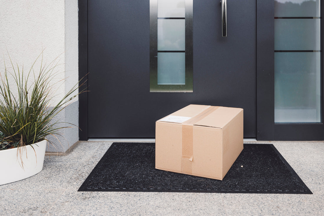 Boite en carton devant une porte d'entrée 